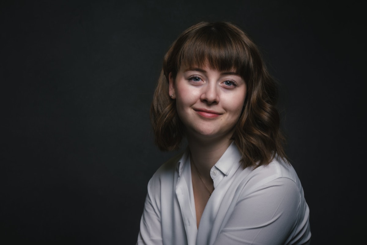 Headshot of Emily Varney, a white woman with shoulder length brown hair and a fringe